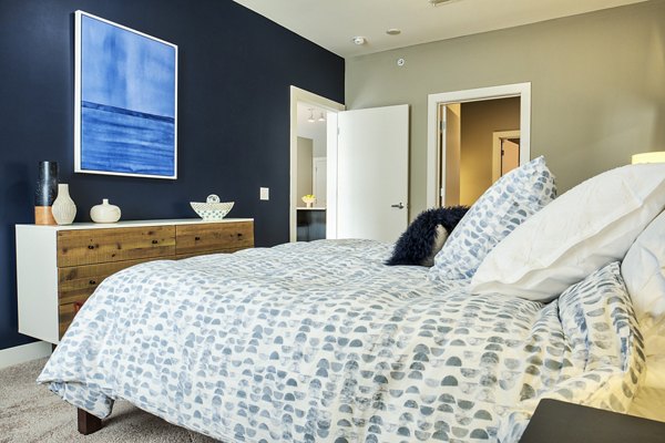 Spacious bedroom with modern furnishings in Ridge at Robinson Apartments, luxury living by Greystar