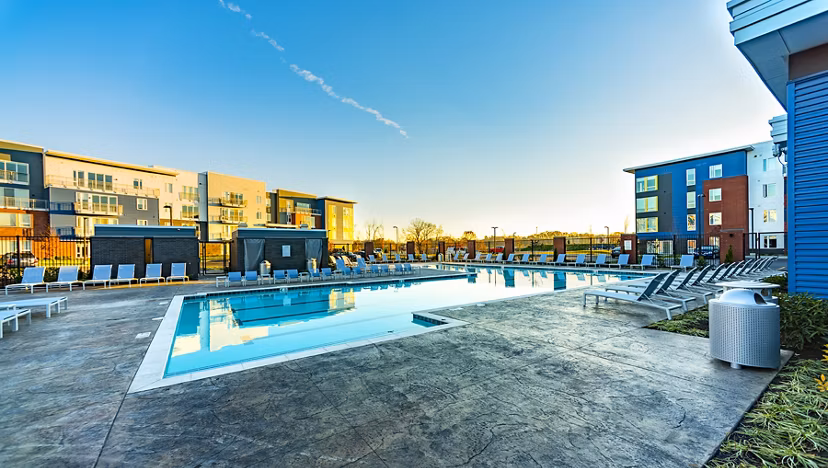 Outdoor pool with sundeck and lounge chairs at Ridge at Robinson Apartments, perfect for relaxation and leisure activities