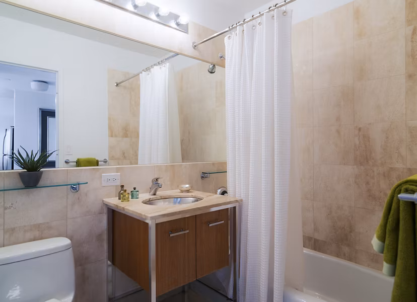 Bathroom featuring sleek countertops and modern fixtures at 800 Sixth Apartments