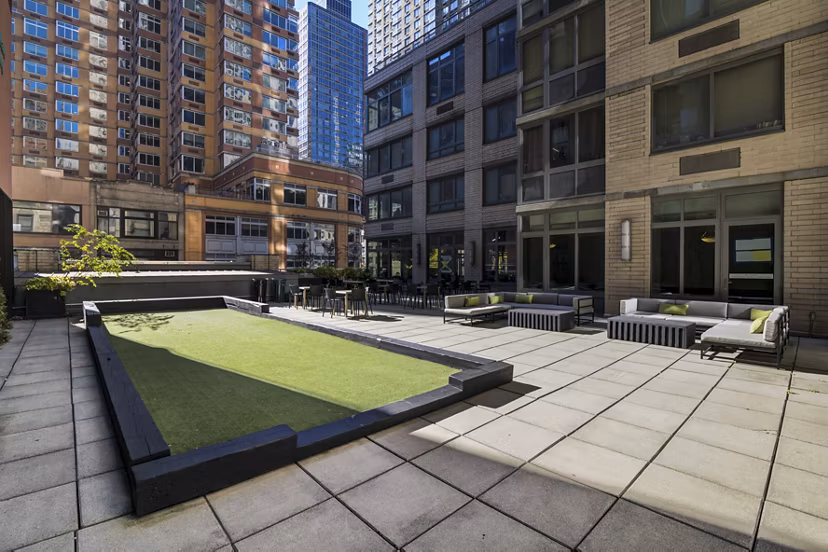 Courtyard featuring modern seating and lush greenery at 800 Sixth Apartments, a luxury property by Greystar in a vibrant urban setting
