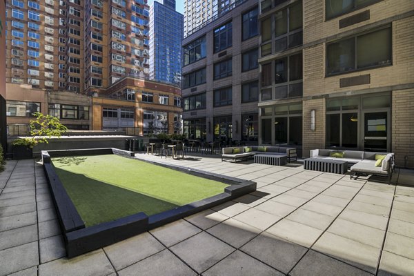 Courtyard featuring modern seating and lush greenery at 800 Sixth Apartments, a luxury property by Greystar in a vibrant urban setting