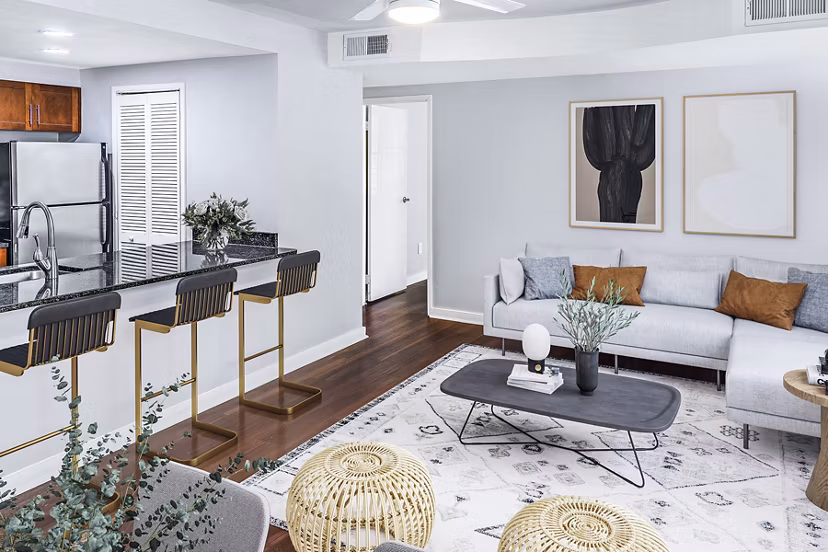 Spacious living room with modern decor in Quaker Court at University City Apartments
