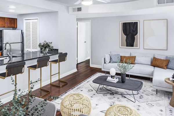 Spacious living room with modern decor in Quaker Court at University City Apartments