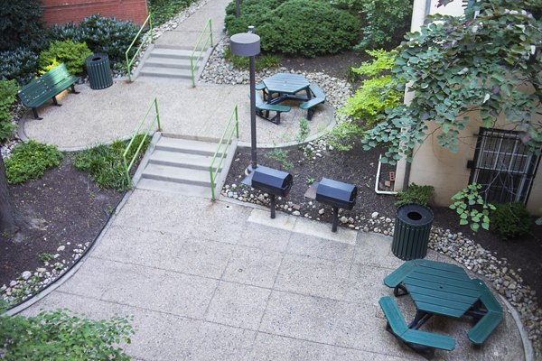 Outdoor grill area with modern seating at Old Quaker Building Apartments, ideal for social gatherings and cooking enthusiasts