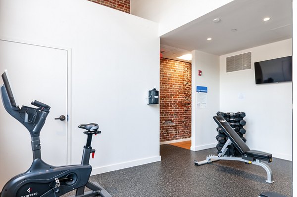 Modern fitness center equipped with state-of-the-art machines at Logan Lofts Apartments