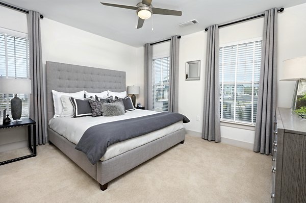 Bedroom featuring modern decor and plush bedding at Avia Apartments