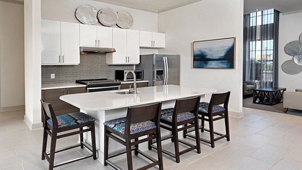 Modern kitchen with sleek countertops and stainless steel appliances in Avia Apartments