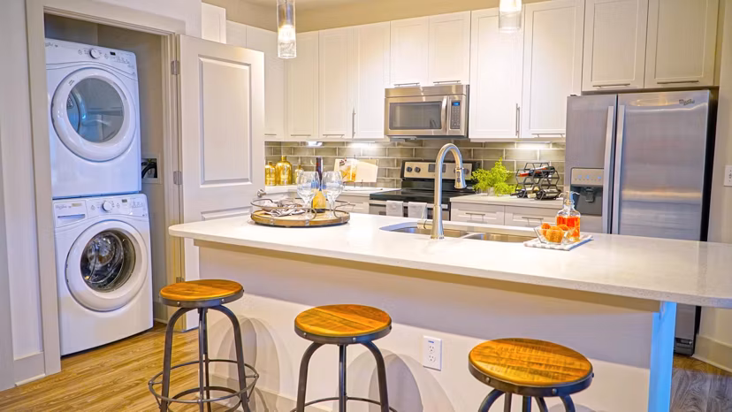 Modern kitchen featuring stainless steel appliances and granite countertops in Avia Apartments luxury living space