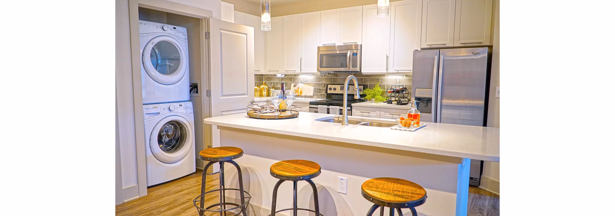 Modern kitchen featuring stainless steel appliances and granite countertops in Avia Apartments luxury living space