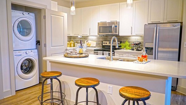 Modern kitchen featuring stainless steel appliances and granite countertops in Avia Apartments luxury living space