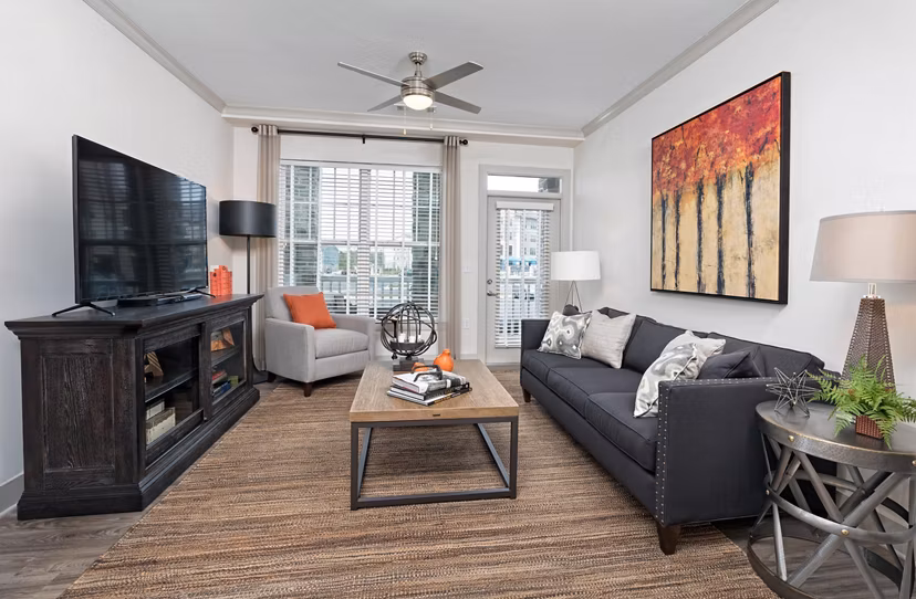 Spacious living room with modern decor and large windows in Avia Apartments, ideal for comfort and style