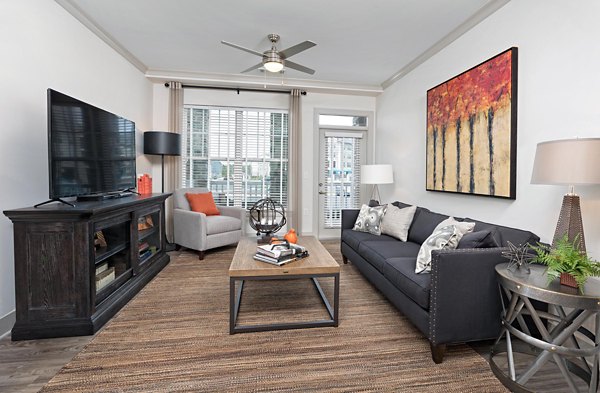 Spacious living room with modern decor and large windows in Avia Apartments, ideal for comfort and style