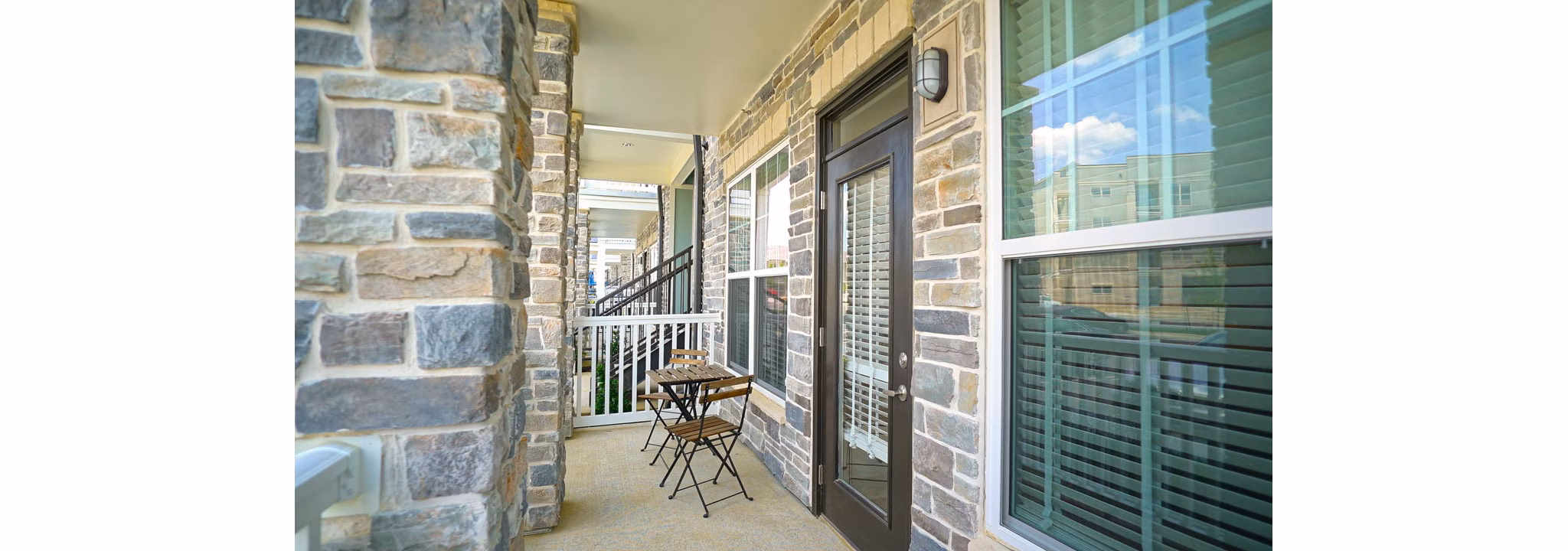 Modern patio with comfortable seating at Avia Apartments, perfect for outdoor dining and relaxation