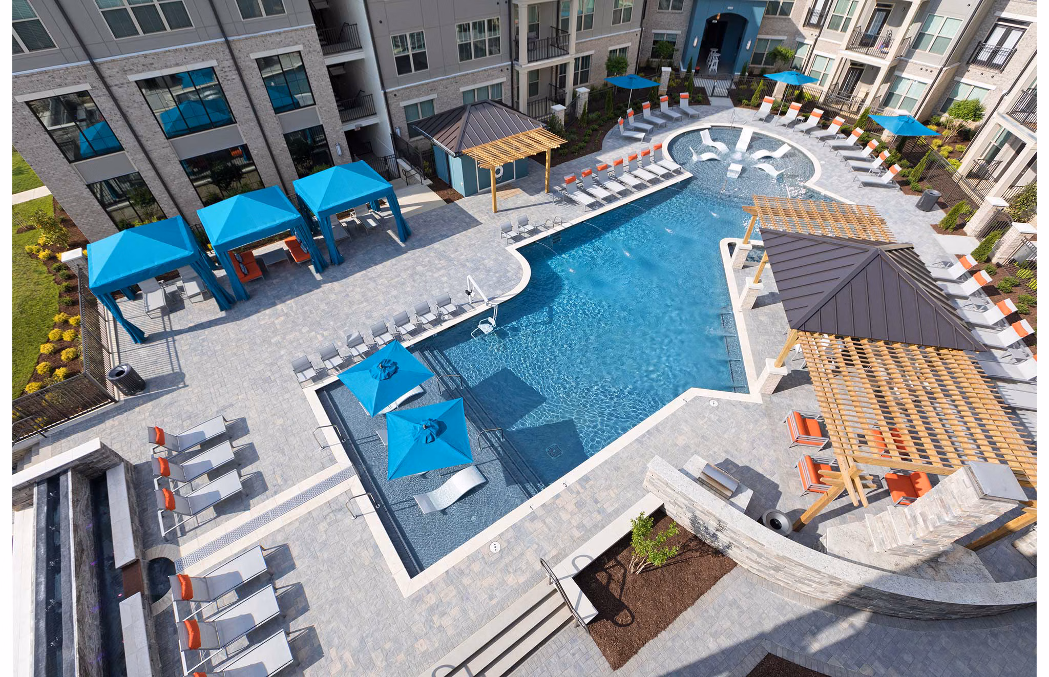 Resort-style pool surrounded by lush landscaping at Avia Apartments