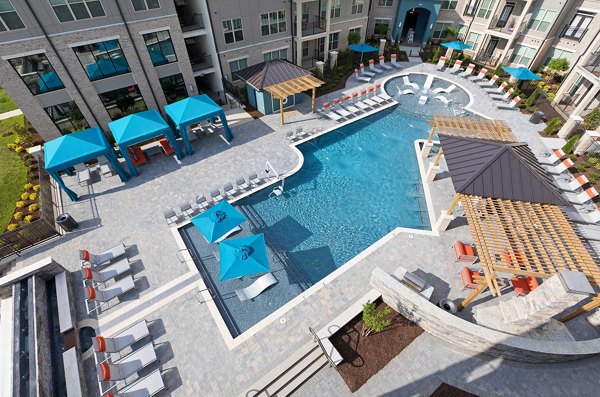 Resort-style pool surrounded by lush landscaping at Avia Apartments