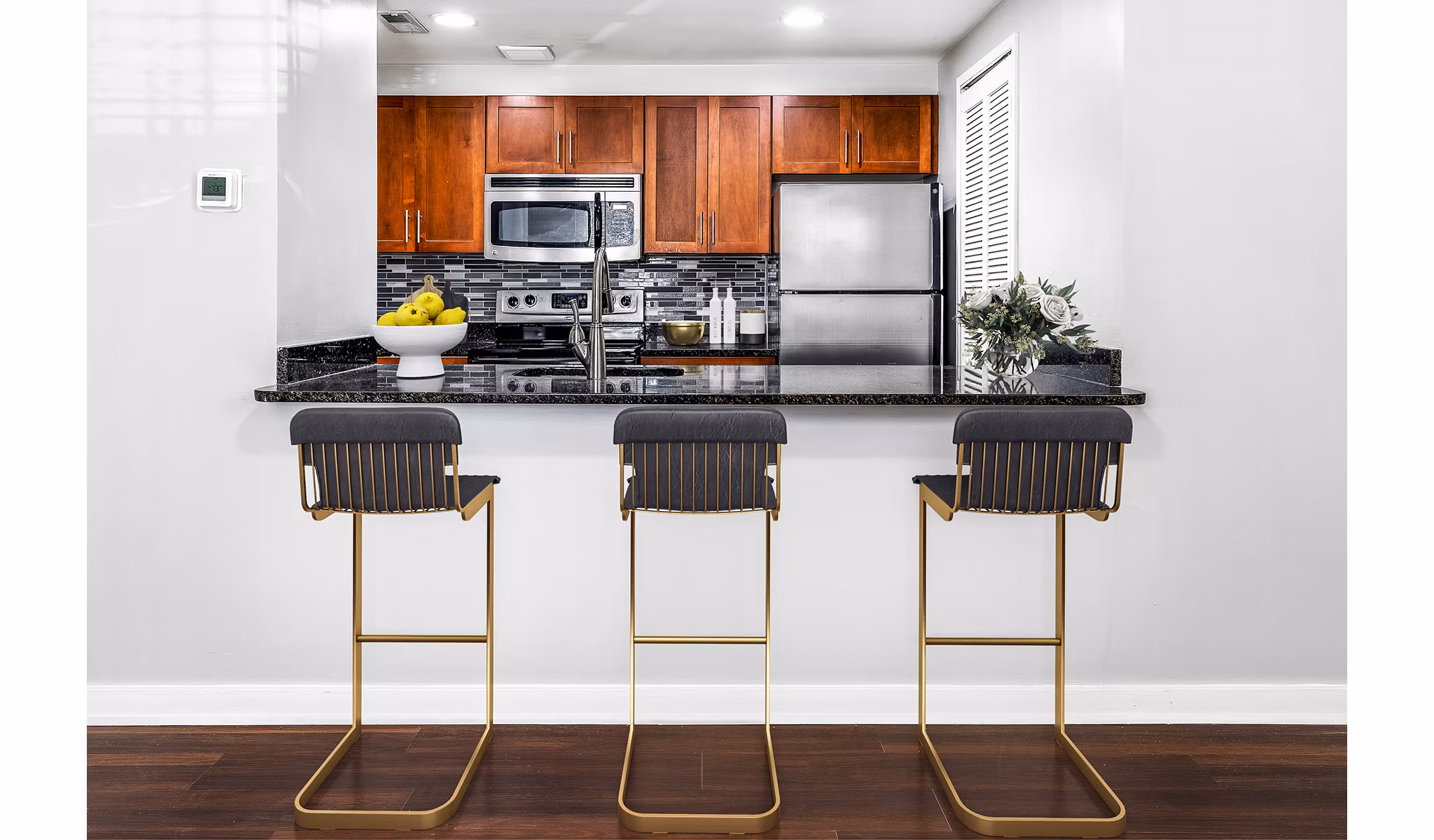 Modern kitchen and dining area with stainless steel appliances at Quaker Court at University City Apartments