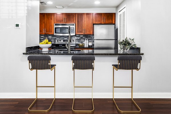 Modern kitchen and dining area with stainless steel appliances at Quaker Court at University City Apartments