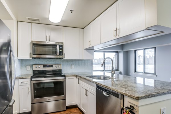 Contemporary kitchen with sleek cabinetry and modern appliances at Half Moon Harbour Apartments