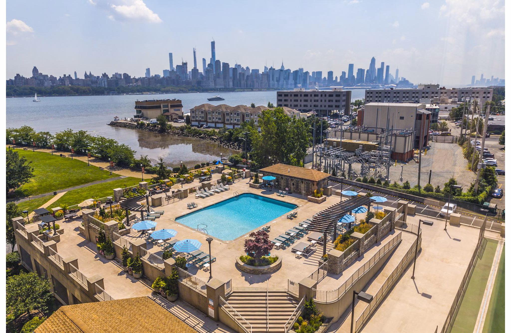 Pool with sleek lounge chairs at Half Moon Harbour Apartments offering luxury waterfront views