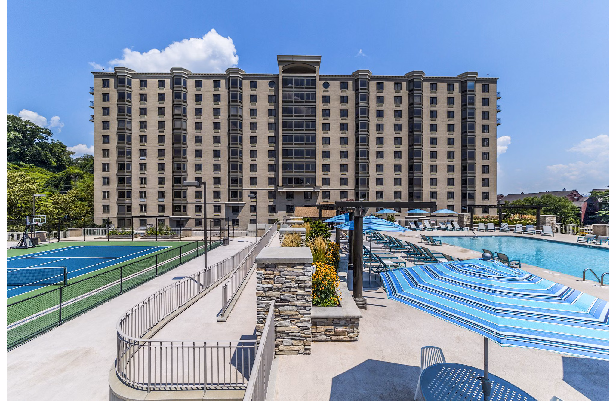 Outdoor pool with nearby tennis court at Half Moon Harbour Apartments offering recreational amenities and luxury living