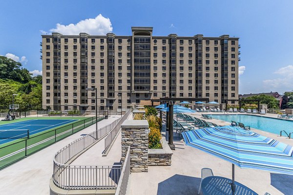 Outdoor pool with nearby tennis court at Half Moon Harbour Apartments offering recreational amenities and luxury living