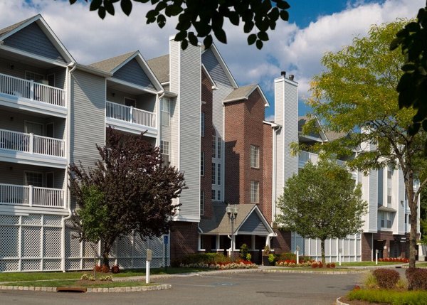 Luxury apartment building with balconies and lush landscaping in a green residential community