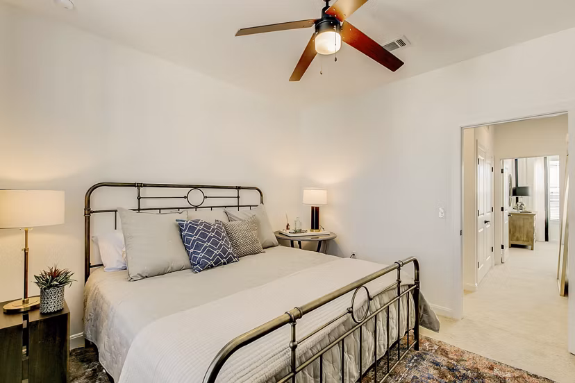 Cozy bedroom featuring modern furnishings and large windows at Elan Inwood Apartments