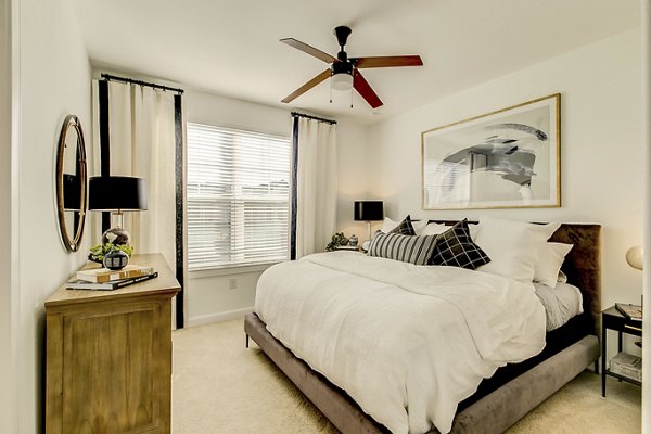 Elegant bedroom with modern decor and large windows at Elan Inwood Apartments