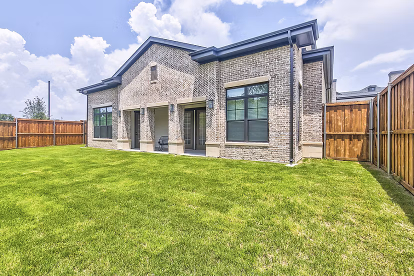 Tranquil backyard with lush landscaping and seating area at Elan Inwood Apartments