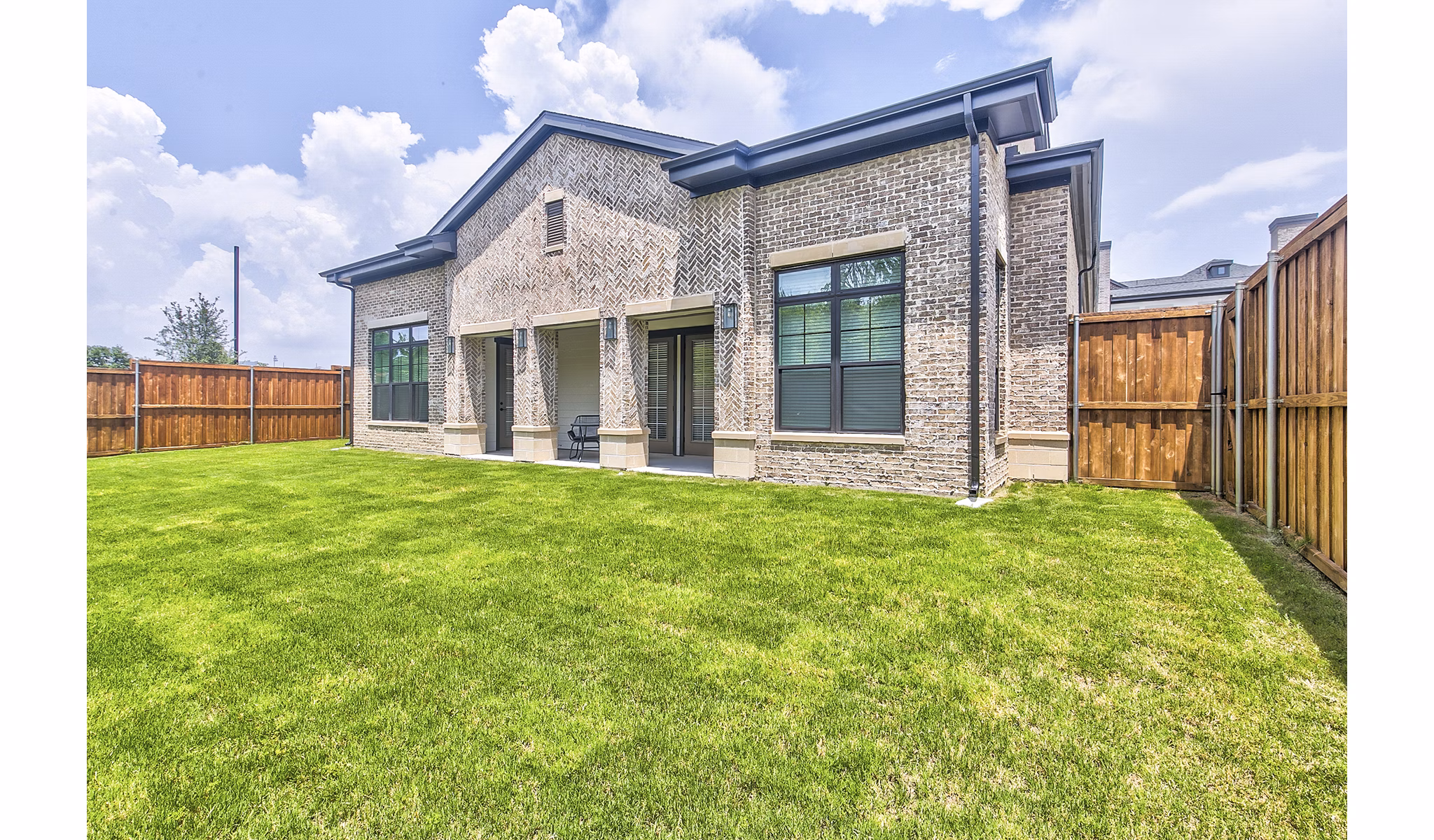 Tranquil backyard with lush landscaping and seating area at Elan Inwood Apartments