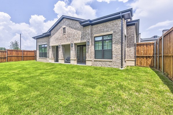 Tranquil backyard with lush landscaping and seating area at Elan Inwood Apartments