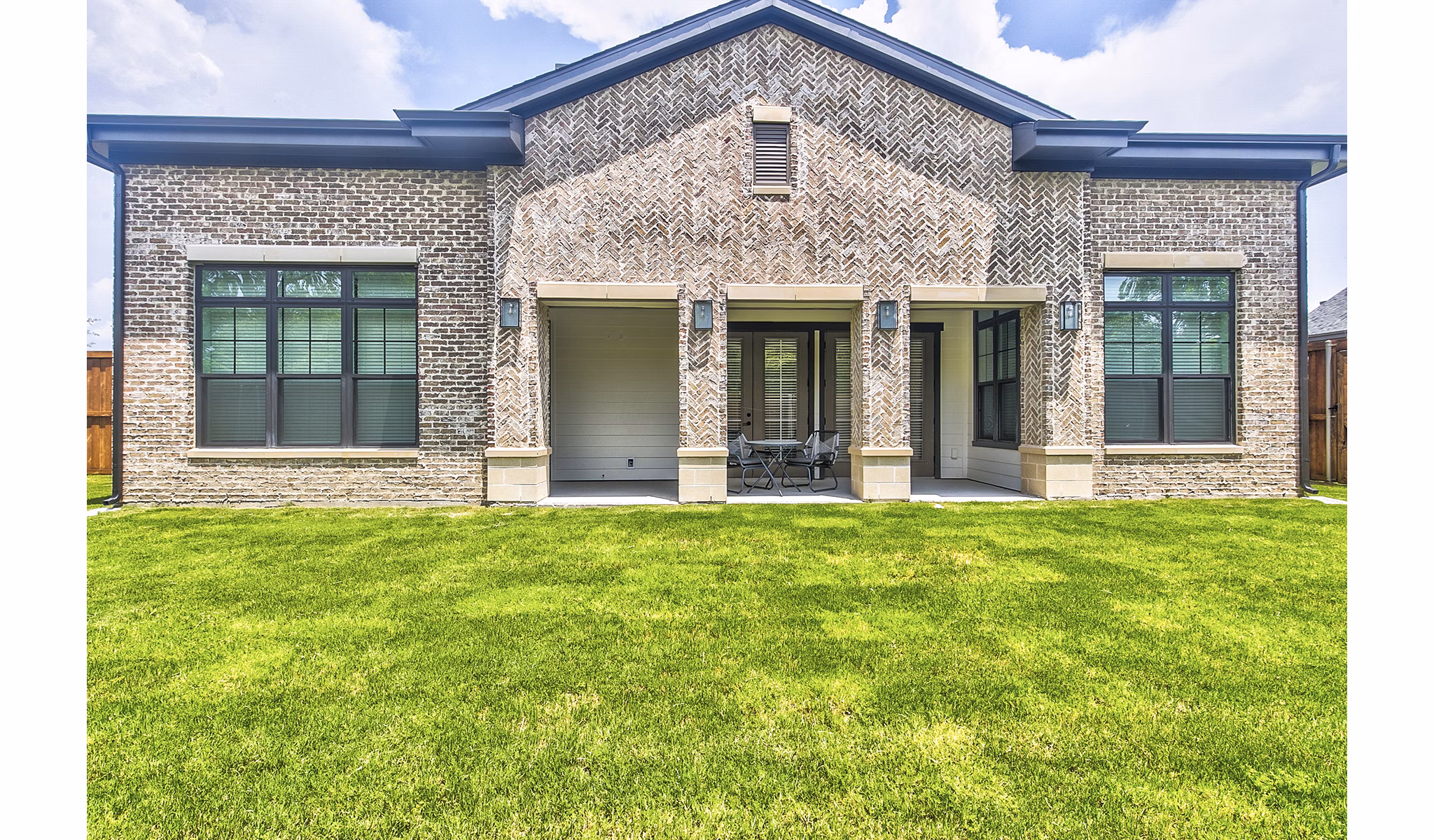 Backyard patio featuring cozy seating and lush landscaping at Elan Inwood Apartments