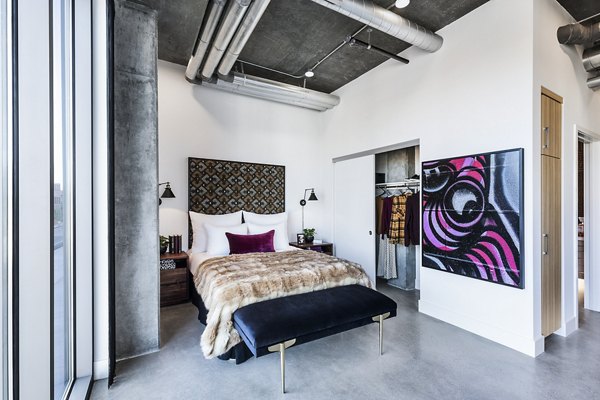 Cozy bedroom featuring modern decor and ample natural light at AMP Lofts Apartments