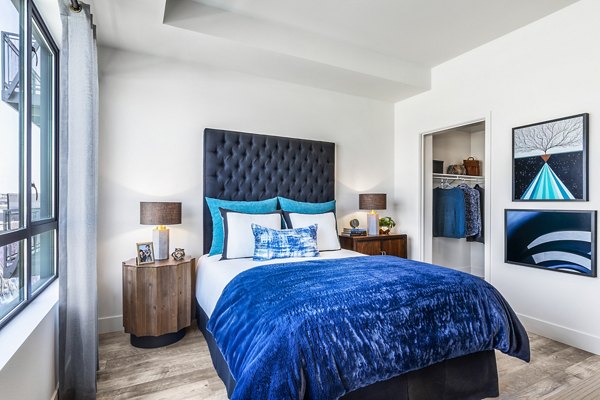 Cozy bedroom with minimalist decor at AMP Lofts Apartments in Los Angeles