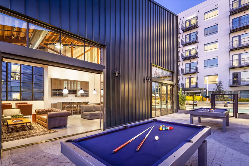 Modern game room with foosball table and lounge seating at AMP Lofts Apartments