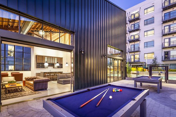 Modern game room with foosball table and lounge seating at AMP Lofts Apartments