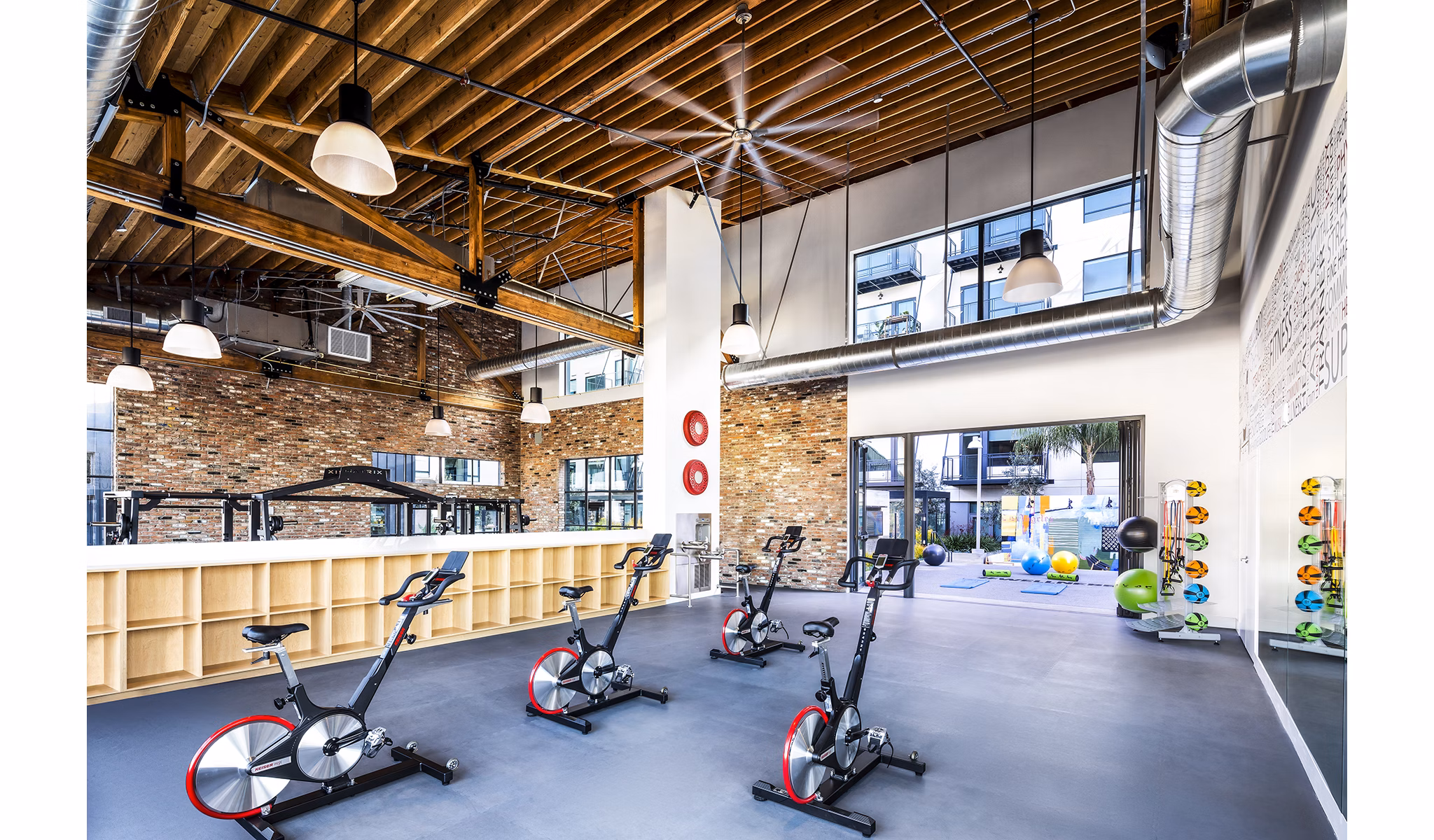 Bright yoga/spin studio with modern equipment at AMP Lofts Apartments, offering a vibrant fitness experience