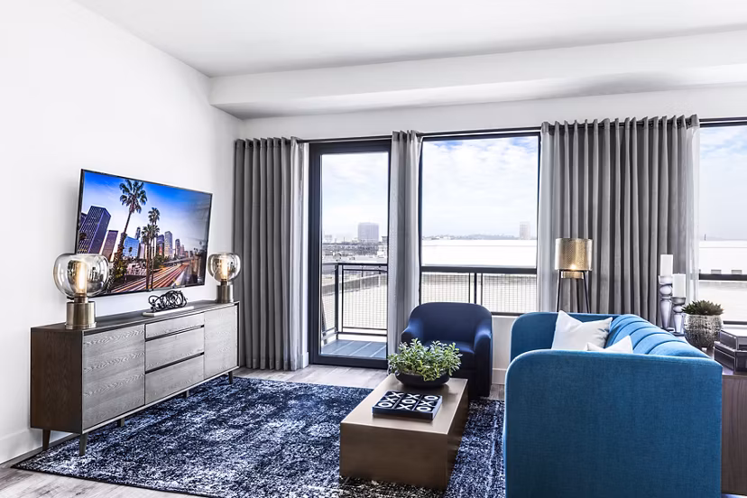 Spacious living room with industrial design elements at AMP Lofts Apartments, featuring modern furniture and open layout
