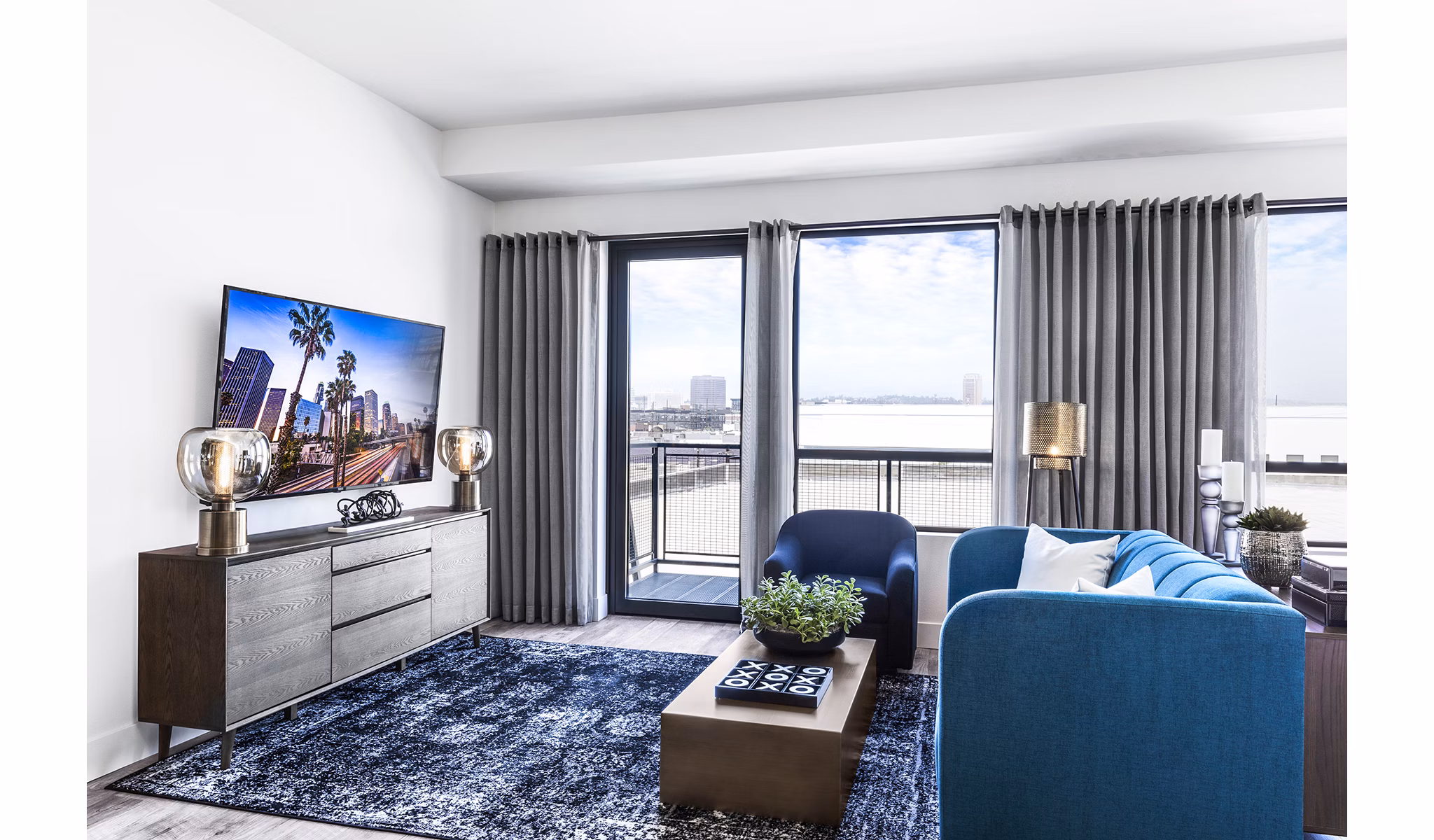 Spacious living room with industrial design elements at AMP Lofts Apartments, featuring modern furniture and open layout
