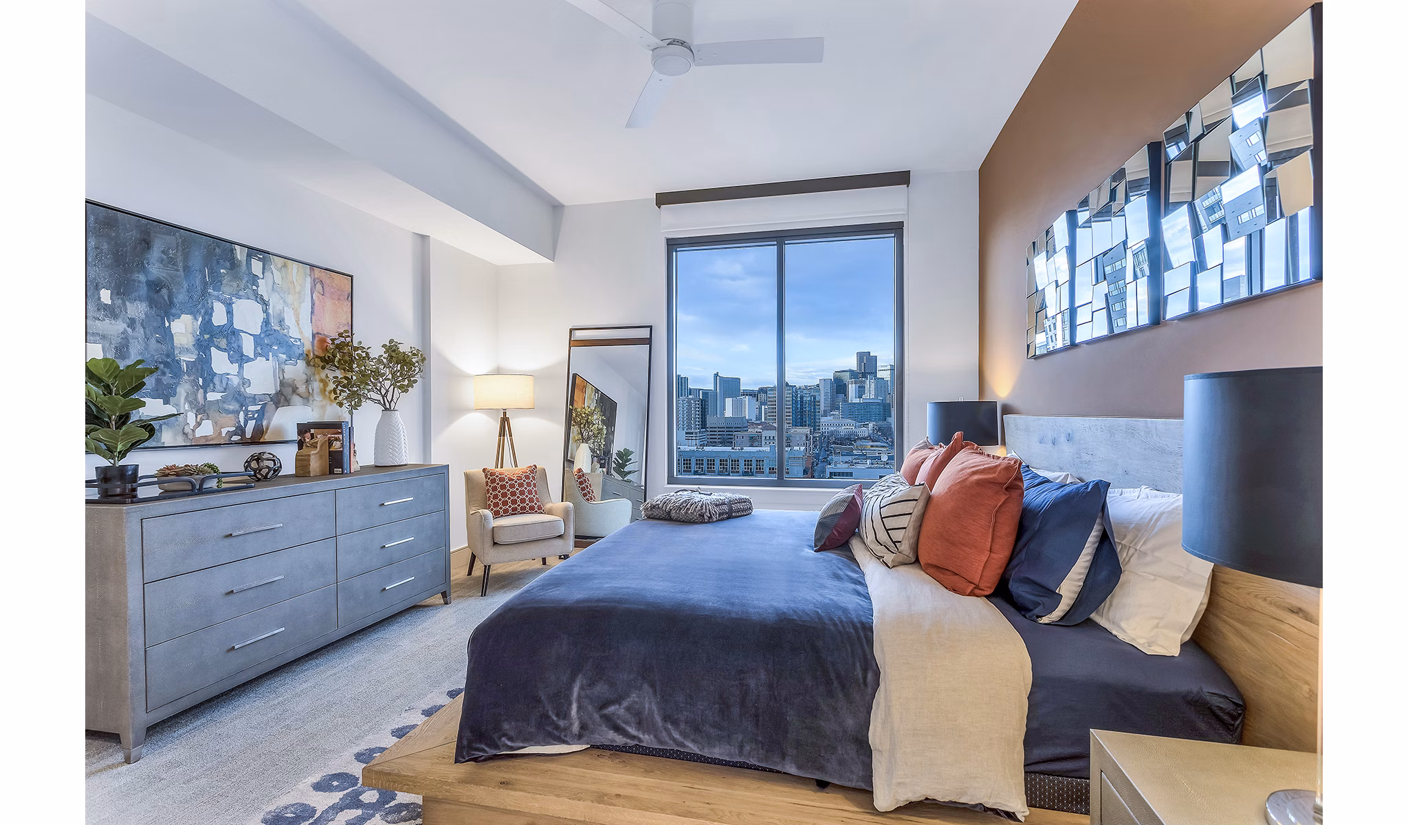 Stylish bedroom with city view, large bed, and modern decor at Parq on Speer Apartments in downtown Denver