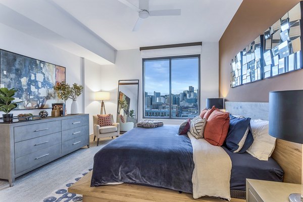 Stylish bedroom with city view, large bed, and modern decor at Parq on Speer Apartments in downtown Denver