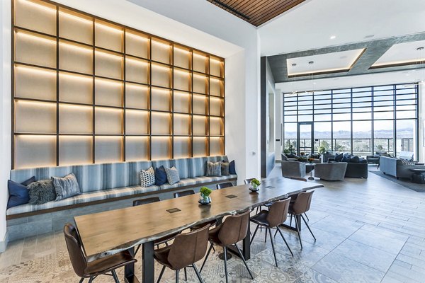 Parq on Speer Apartments: Modern lounge area with long table, chairs, and large windows in luxury setting