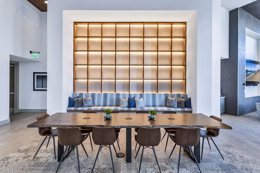 Stylish meeting room with sleek wooden table and cushioned seating at Parq on Speer Apartments in Denver Perfect for coworking or gatherings