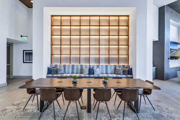 Stylish meeting room with sleek wooden table and cushioned seating at Parq on Speer Apartments in Denver Perfect for coworking or gatherings
