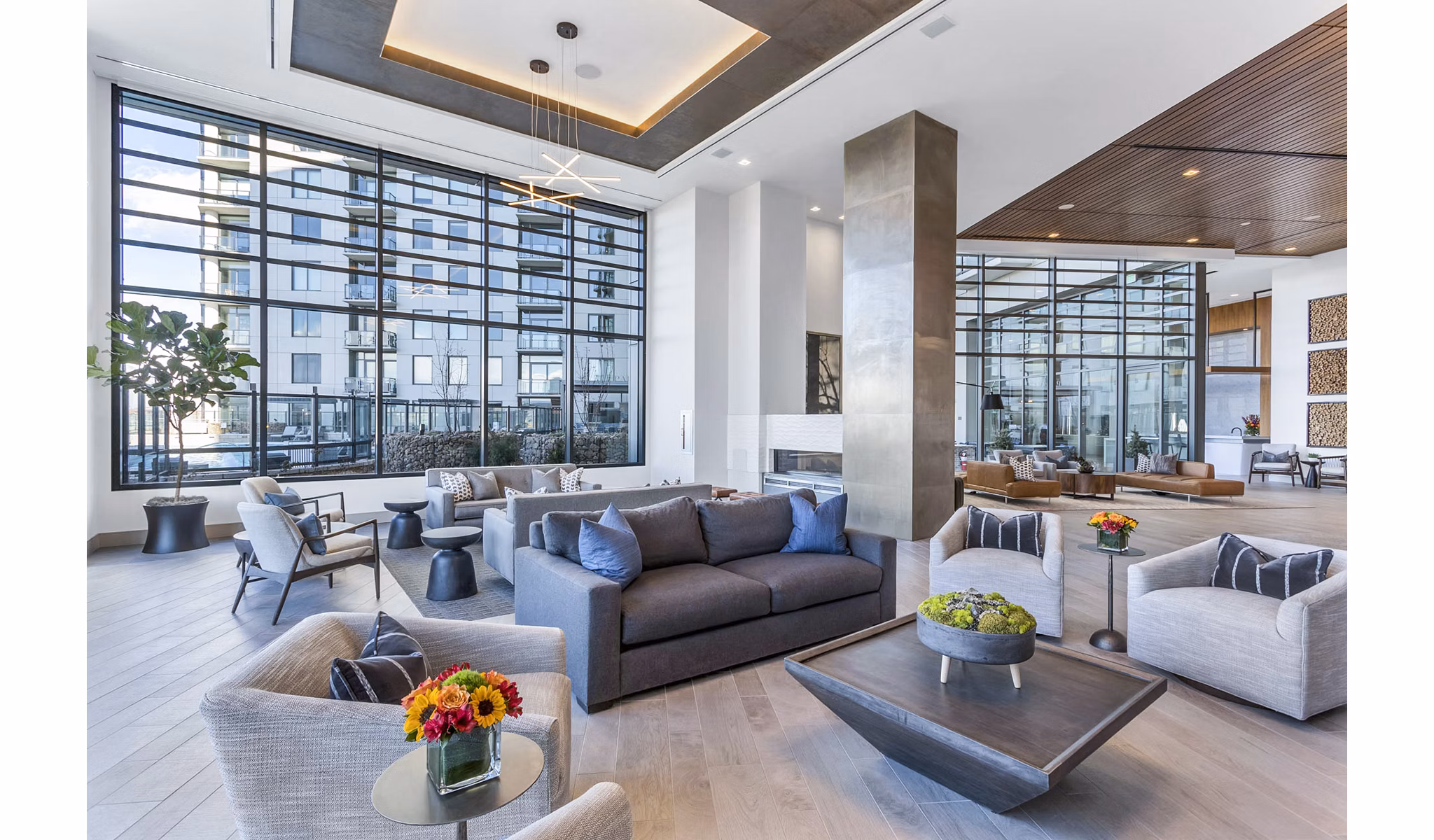 Stylish lounge with large windows and modern seating at Parq on Speer Apartments
