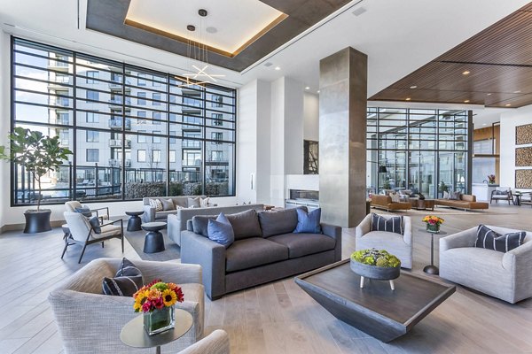 Stylish lounge with large windows and modern seating at Parq on Speer Apartments