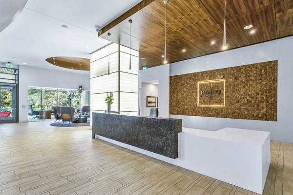 Spacious, stylish lobby with wood accents and large reception desk at Parq on Speer Apartments in Denver