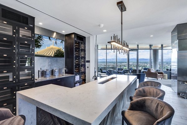 Sleek kitchen with island, bar seating, and large windows at luxury Parq on Speer Apartments in Denver