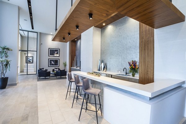 Parq on Speer Apartments: Sleek lobby with bar seating, high ceilings, and contemporary decor in luxury Denver living space