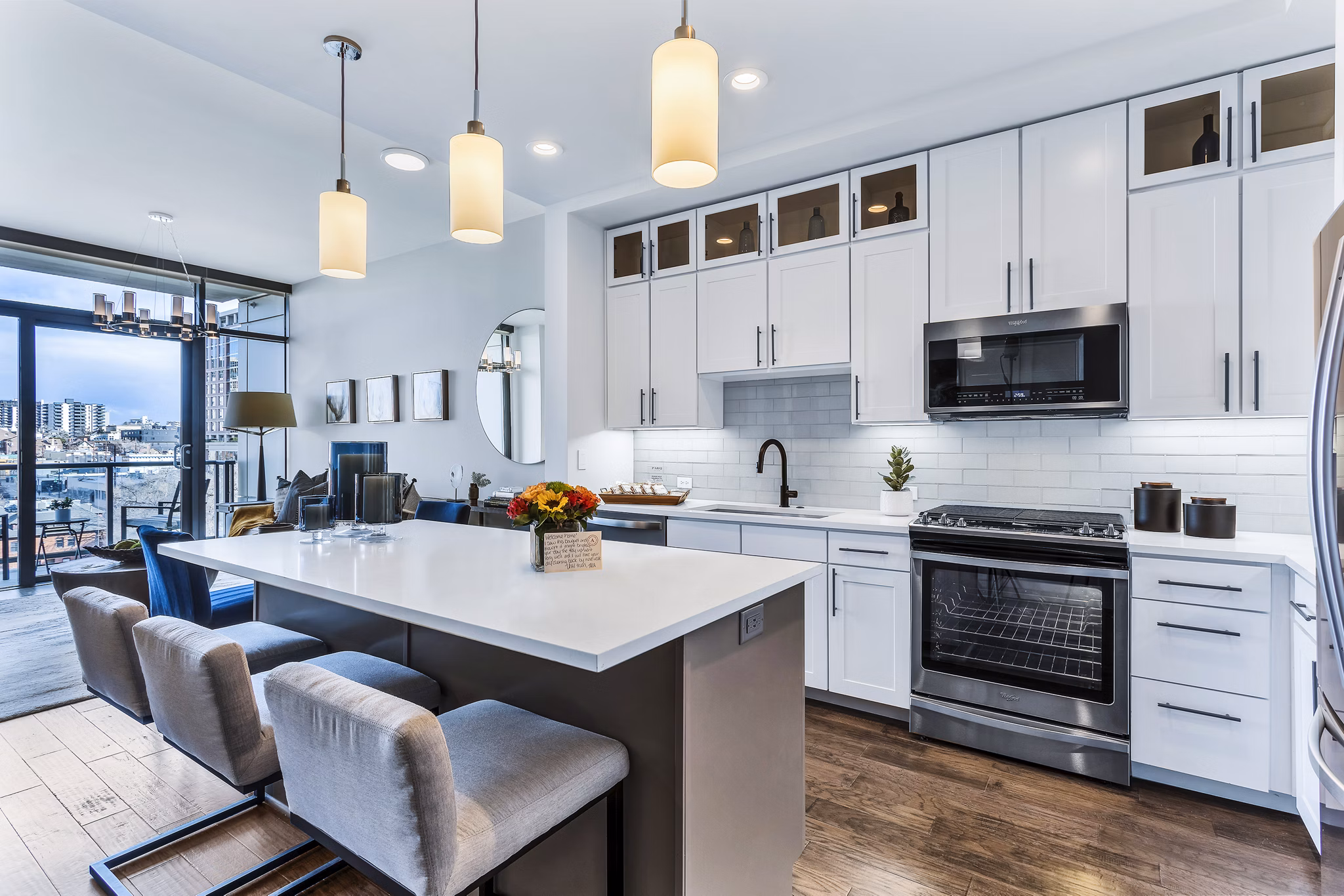 Modern kitchen with island, pendant lights, and stunning city views at Parq on Speer Apartments in Greystar's luxury community